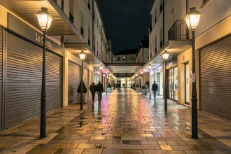 La rue commerçante Le Cardo à Orvault le soir avec éclairage public et quelques passants